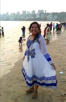 Smiling Indian lady on Mumbai city beach.