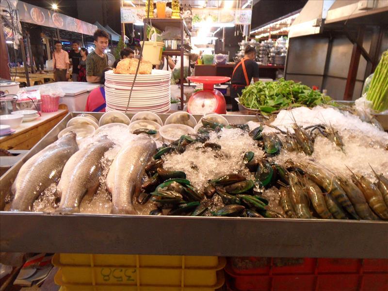 Fresh seafood covered with ice 
 at a street food stall in the Huai Khwang district of Bangkok.