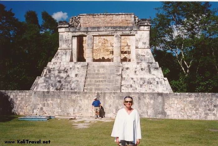 Woman standing in front of Chichen Itza Mayan ruins.