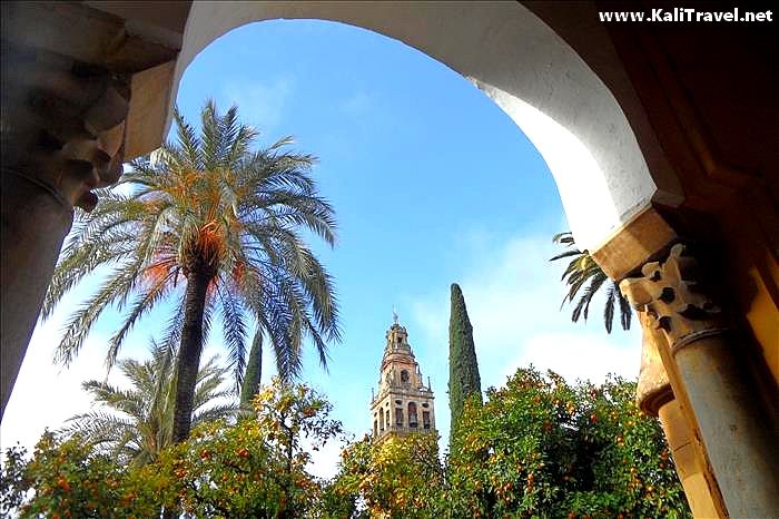 View through an archway to Córdoba's Orange Tree Courtyard and the belltower.