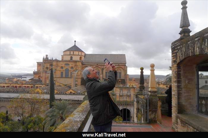 Man taking a photo from the top of the belltower, in front of Córdoba mosque-cathedral.