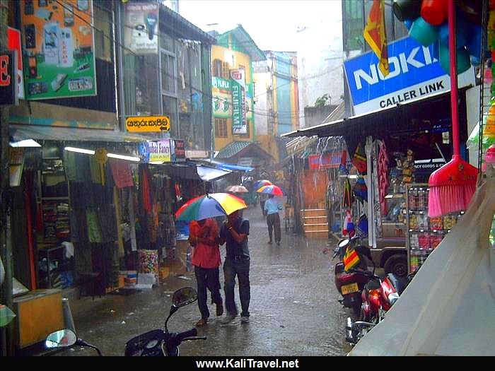 Sri Lankans walking with umbrellas in the rain in Kandy old town.