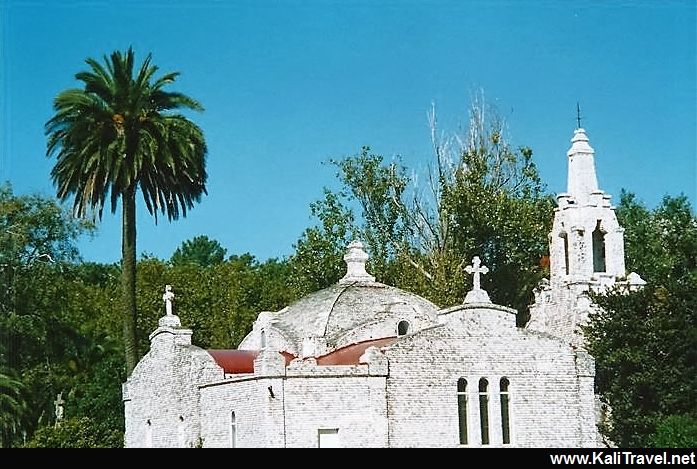 Shell covered La Toja chapel surrounded by trees.
