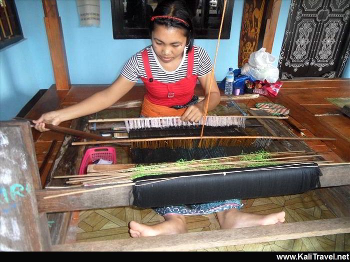 Lady craft worker weaving fabric.