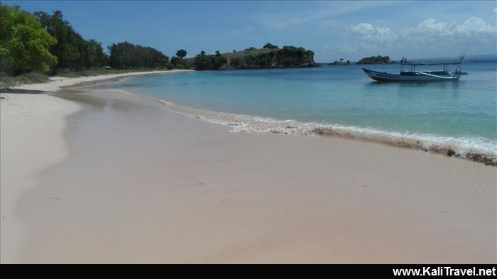 Lombok boat on the sea beaside the sandy pink beach.