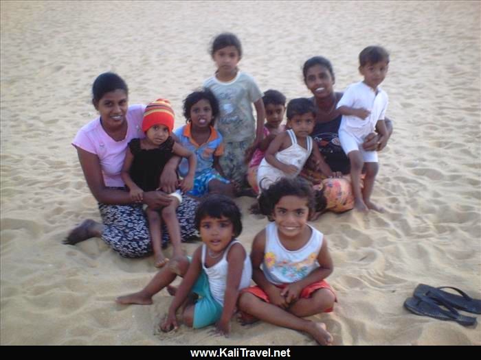 Sri Lankan kiddies sitting on the sands of Negombo beach.