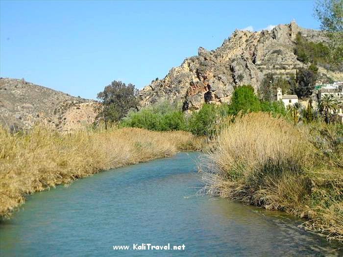 River in a valley with mountains in the distance.