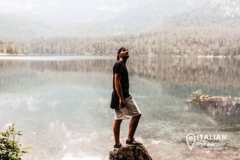 Toti standing by icy Alpine lake in Trentino, Italy.