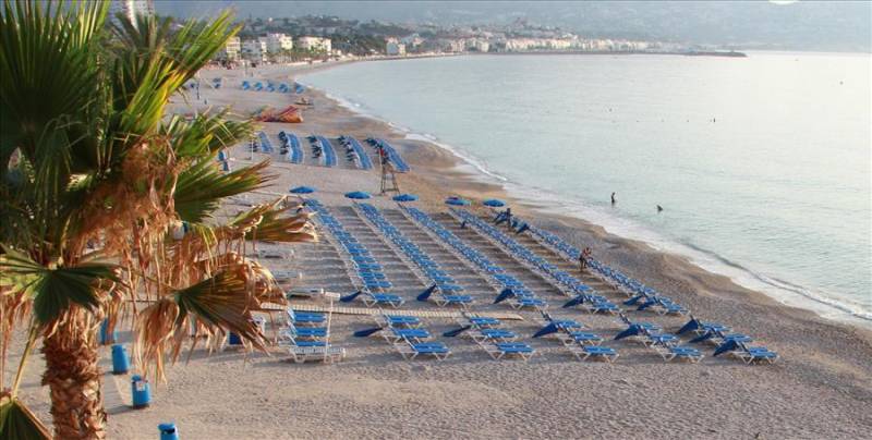 Sunbeds on El Albir pebble beach in Costa Blanca, Spain.