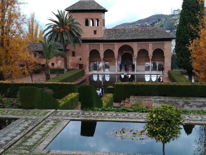 Palacio de color rosa con jardin y estanques.