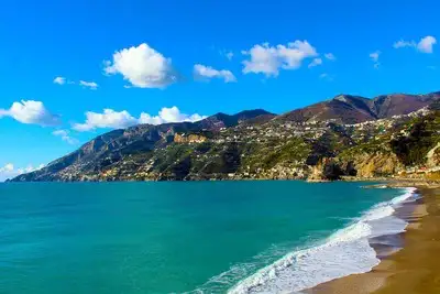 Golden sandy beach, turquoise sea and cliffs of the Amalfi coast.