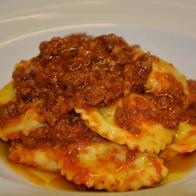 Plate of tordelli lucchesi (tortellini with meat and tomato sauce).
