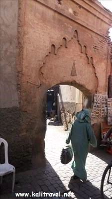 Traditionally dressed woman by an archway Marrakesh Medina.