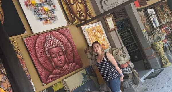 Sharne standing by Balinese paintings in Ubud.