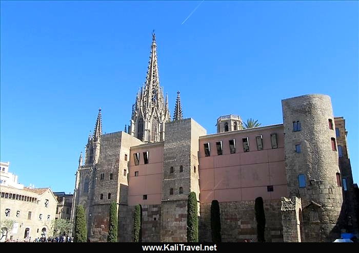 Pink and grey stone façade of St Eulalia Gothic Cathedral with towers and turrets.