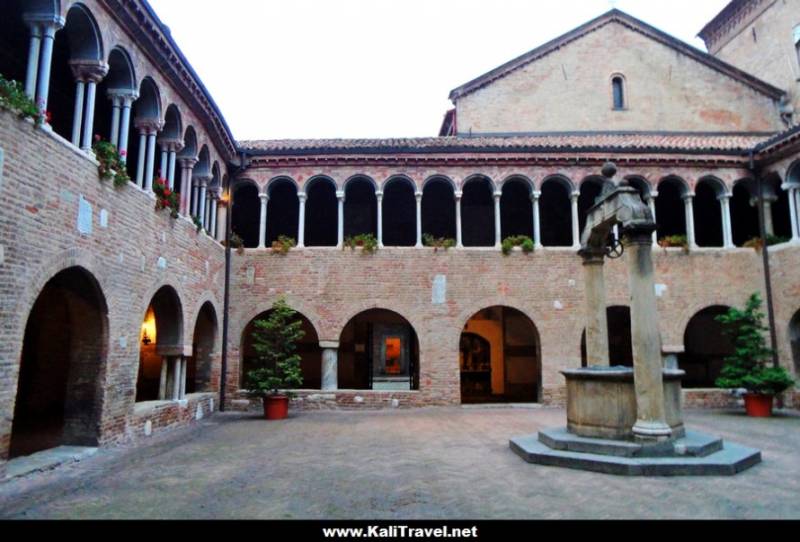 Inner courtyard with wishwell and galleries, Santo Stefano Basilica in Bologna.