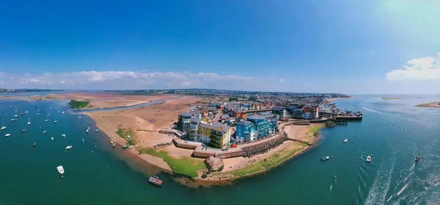 Aerial view of the sea curving around Exmouth town and estuary sandbanks.
