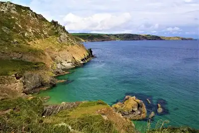 Grassy cliifs and aquamarine sea.