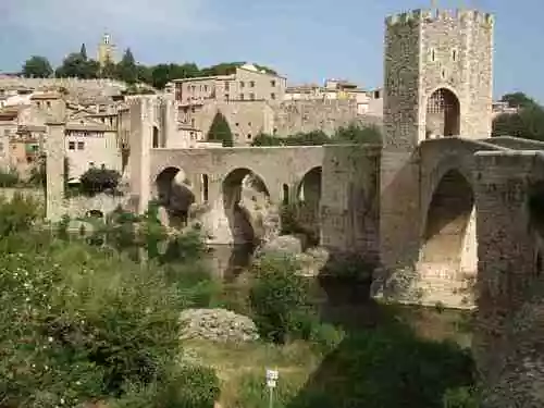 Stone bridge with arches and tower, crossing river to Besalu medieval town.