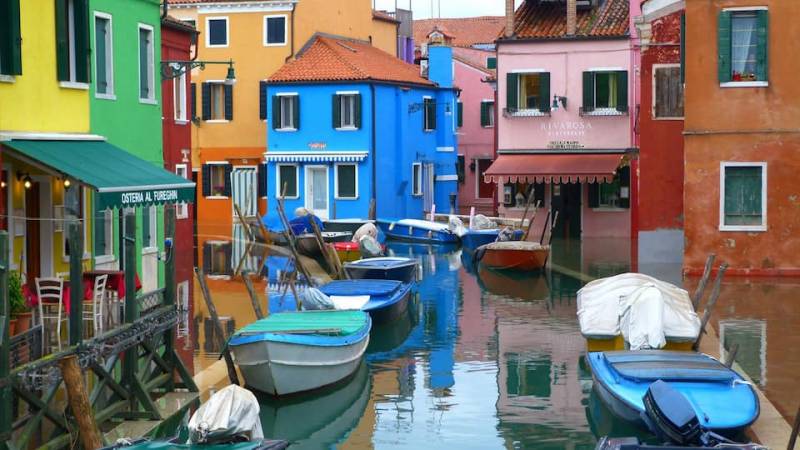 Burano Island canal scene with colourful houses and boats in the Venetian Lagoon, Italy.