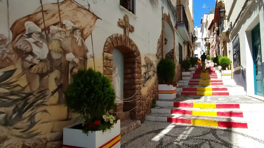 Calpe old town passageway with red and yellow steps painted in the colours of the Spanish flag.