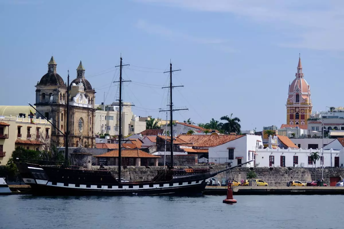 Barco de epoca en el puerto con los edificios coloniales de Cartagena al fondo.