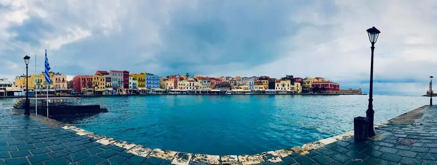 View over Chania harbour waterfront to quaint colourful buildings.