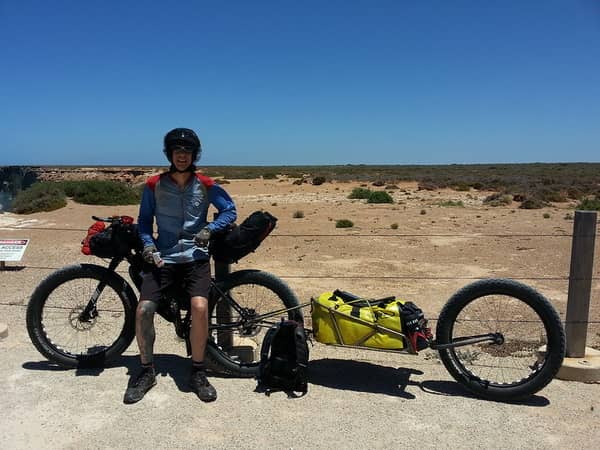 Cyclist in front of bike on Nullarbor Plain.