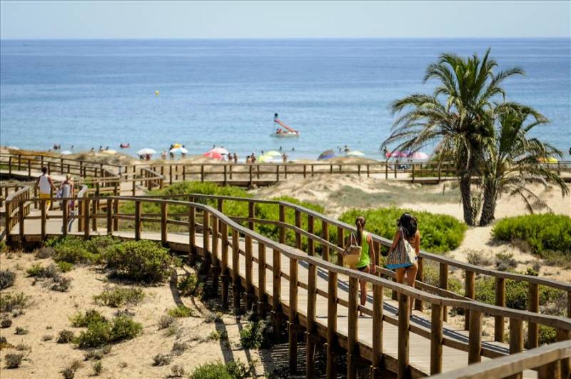 Boardwalk over sand dunes at Arenelaes De Sol beach in Costa Blanca.