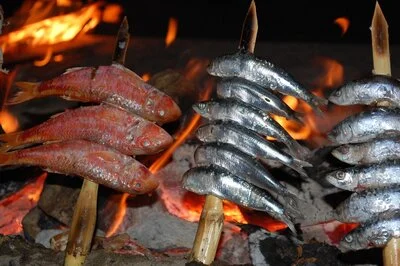 'Espeto' fish on BBQ wood stakes over beach fire in Málaga.