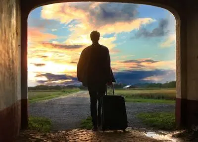 Traveller with a trolley bag arriving at a sustainable tourism destination.