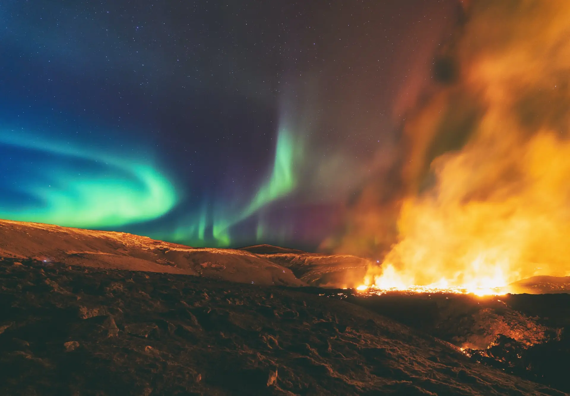 Flaming magna and northern lights over Fagradalsfja in Iceland.