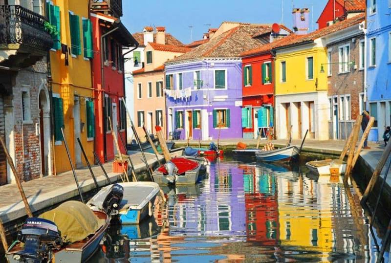 Colourful fishermen's house houses reflecting in Burano a canal, Venice Lagoon Islands.