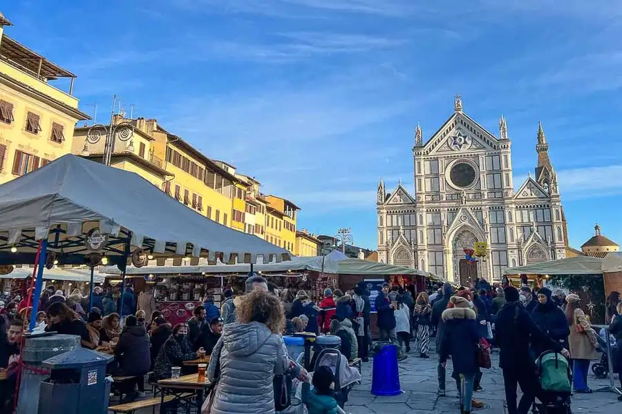 Busy Christmas market with Florence cathedral in the background.