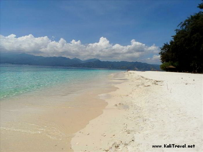 White sands beside calm turquoise sea on the shores of Gili Meno paradise island.