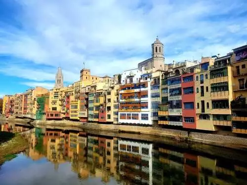 Colourful buildings of Girona reflecting on the river.
