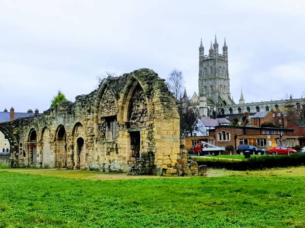 View across the grass to ruins & the cathedral in Gloucester city near London.