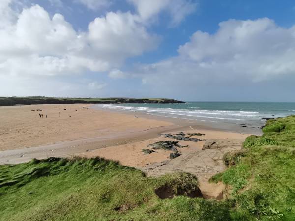 Grassy clifftop, views over the sands of Harlyn Bay on a summer visit to Cornwall.