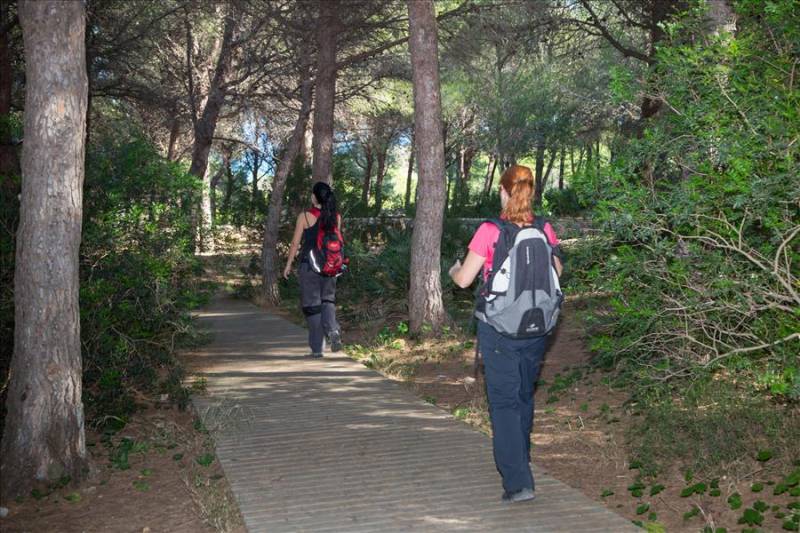 2 women trekking through woods in the Costa Blanca, Spain.