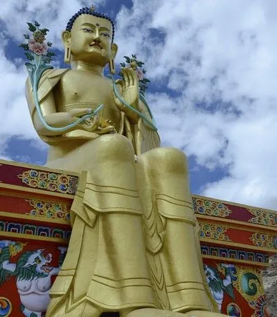 Gran estatua dorada de Buda sentada al aire libre.