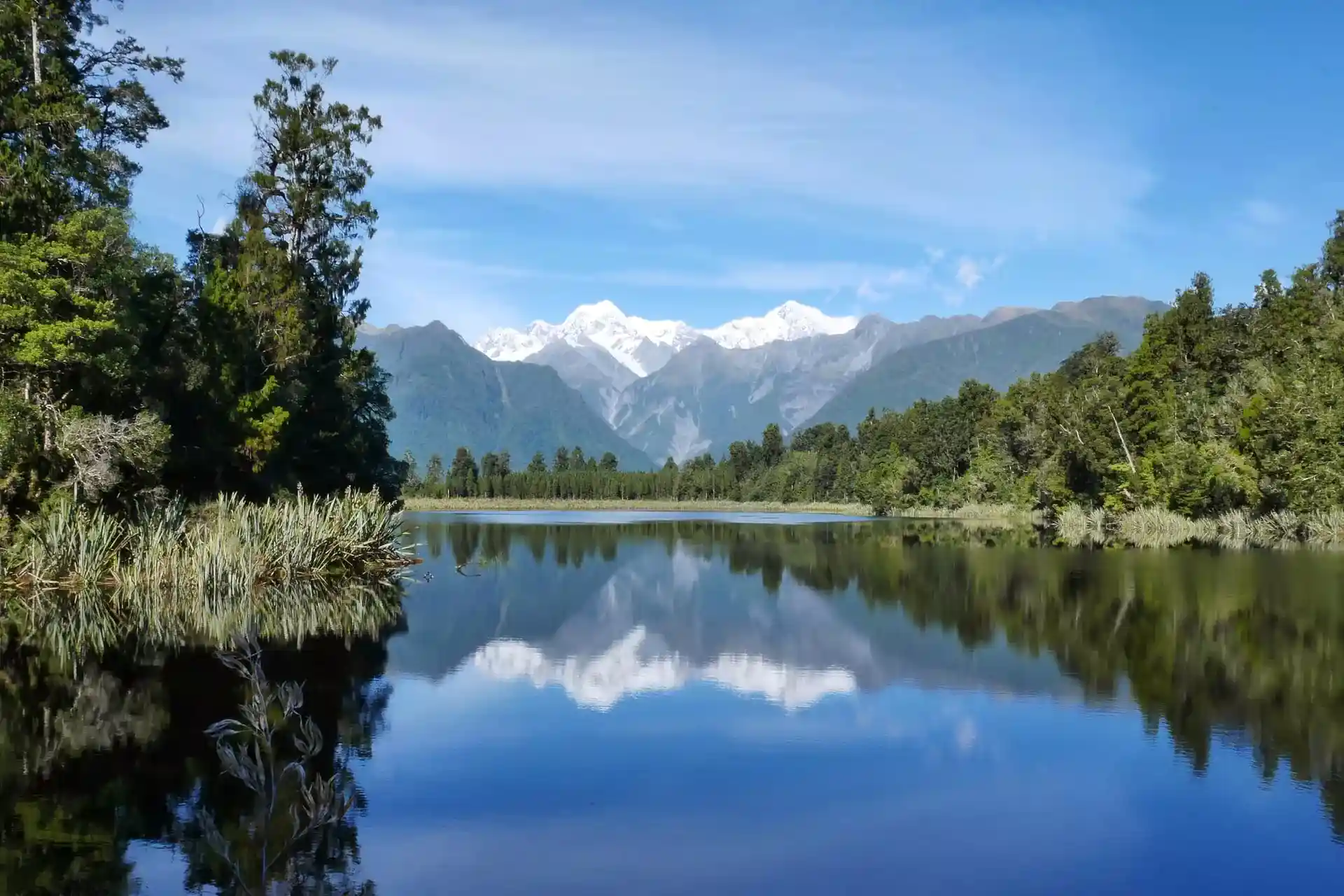 Snow-topped mountains reflecting in the lake.