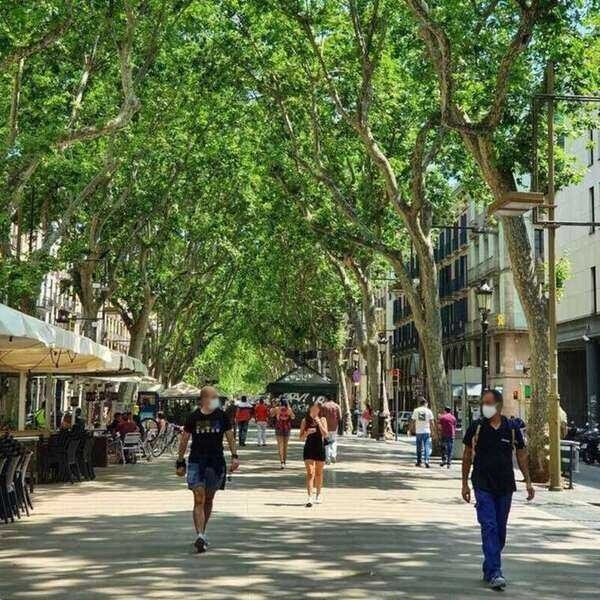 2 hombres caminando por avenida Las Ramblas en Barcelona.