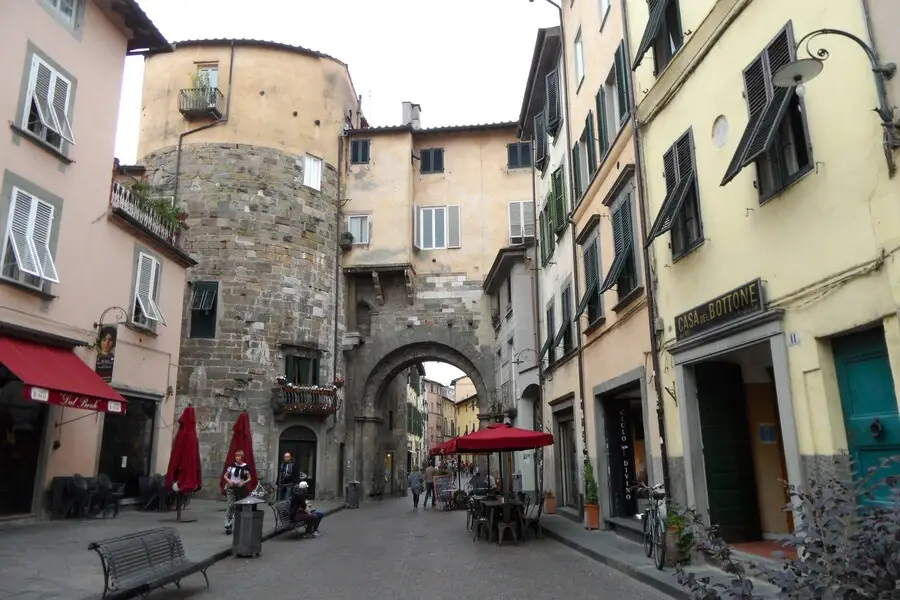 Stone archway in medieval shopping street.