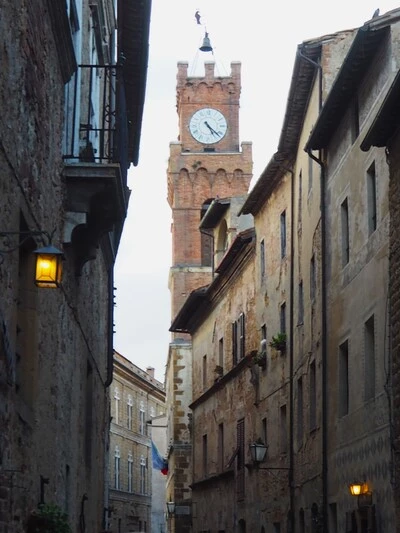 Lucca clocktower torre delle ore at the end of a narrow street.