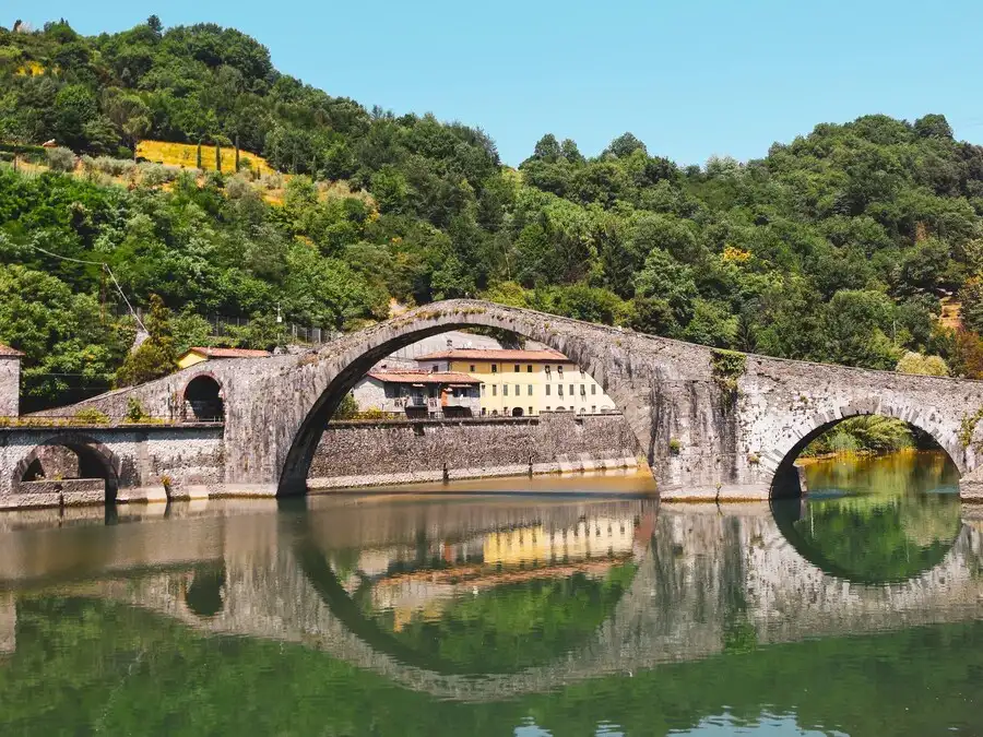 Ancient arched stone bridge reflecting in the river.
