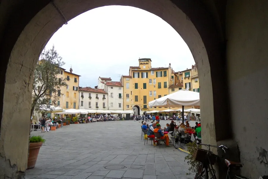 View through an archway to restaurant terraces in ancient Piazza dell’Anfiteatro. 