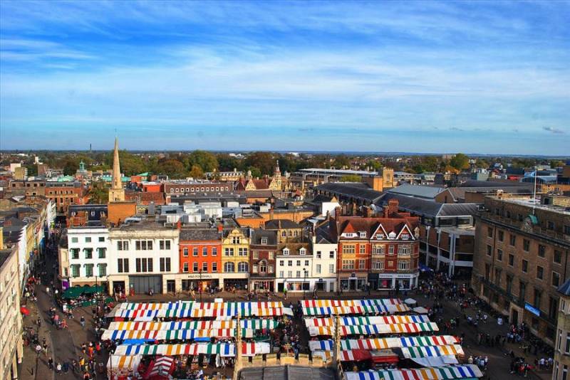 Aerial view of stalls in Market Square surrounded by historic buildings in Cambrige, UK.