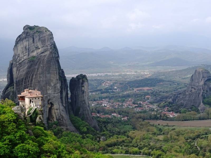 A monastery in front of a huge rock pillar in Meteora, Greece.