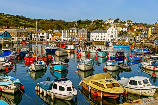 Quaint fishing boats in Mevagissey harbour on a summer day in Cornwall.