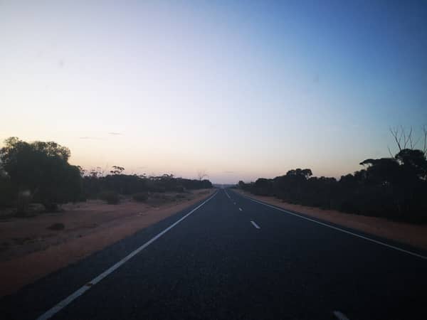 Longest, straight road across the plain in fading light.